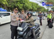 Kapolres Pelabuhan Belawan Bagikan Bendera Merah Putih kepada Pengendara di Depan Kantor Pelindo Belawan